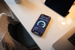Teléfono móvil sobre una mesa de escritorio mostrando en pantalla la app de un test de velocidad de internet.