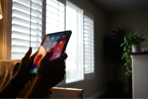 Persona utilizando una tablet frente a la ventana