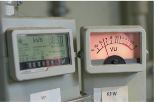 Primer plano de contadores de consumo eléctrico y energético con pantalla digital e indicador analógico.